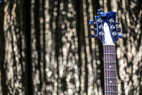 户外点状灯光前黑色吉他乐器