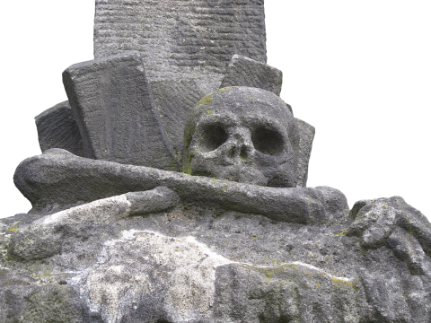 白色背景前雕刻成骷髅头和墓碑的石头