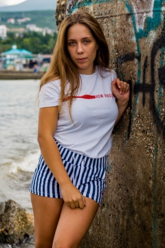 靠墙壁穿短袖T恤短裤时尚长发女性