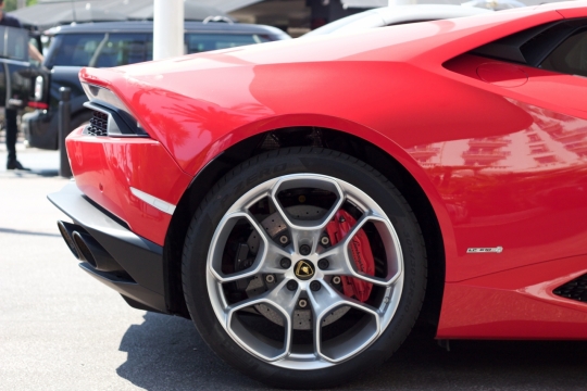 阳光城市街道豪华红色轿车侧面车尾