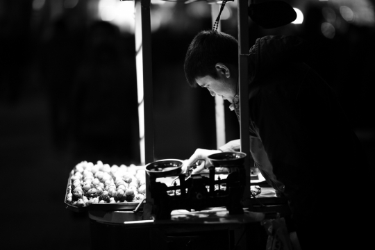 黑白夜晚城市街道小摊前男性