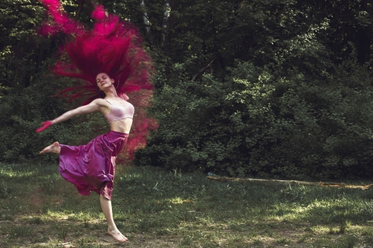 红色长裙长发美女在草地上跳舞