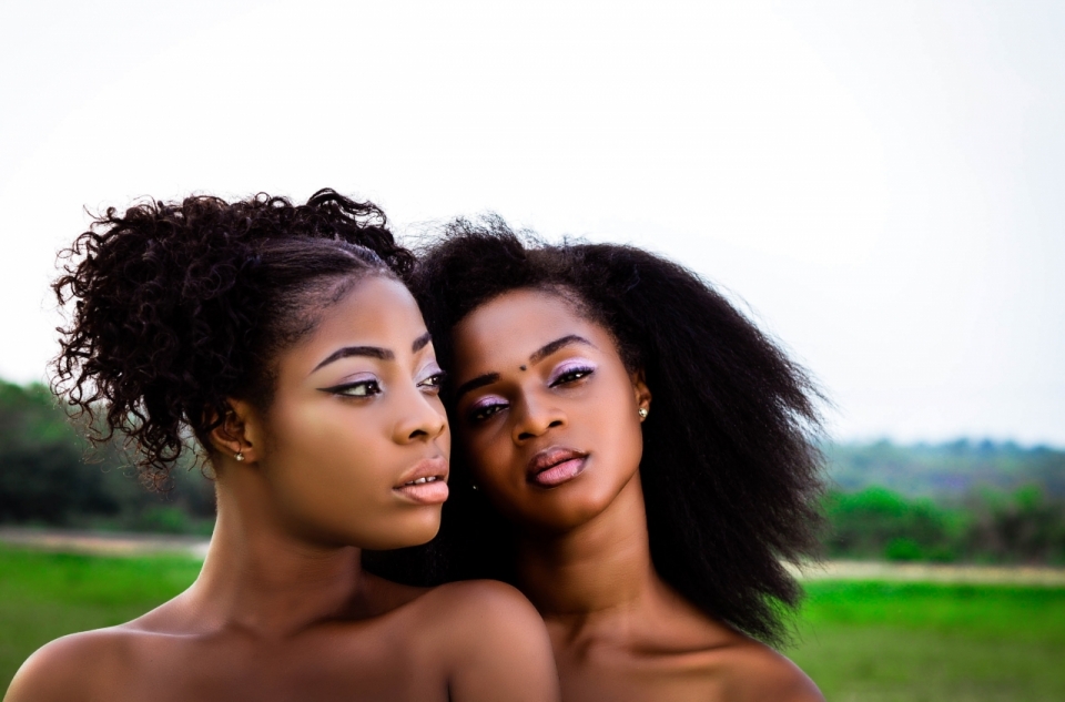 两个外国黑人姑娘在草地上露出双肩做妩媚动作