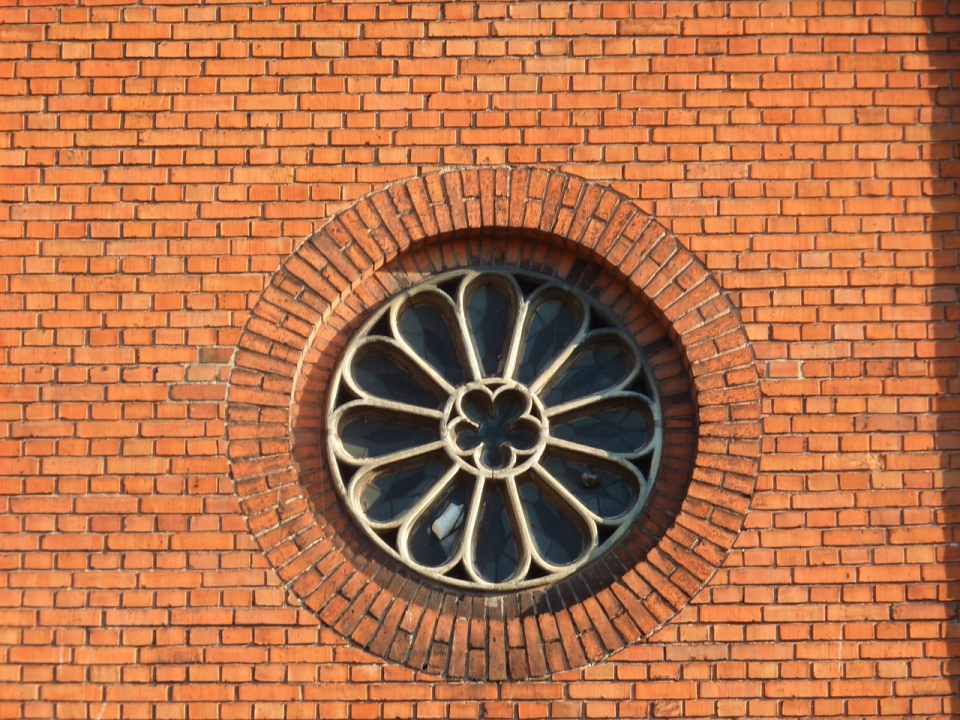 石砖墙壁建筑上圆形花朵窗户