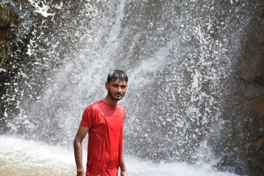 自然瀑布前红色T恤短发蓄胡男性