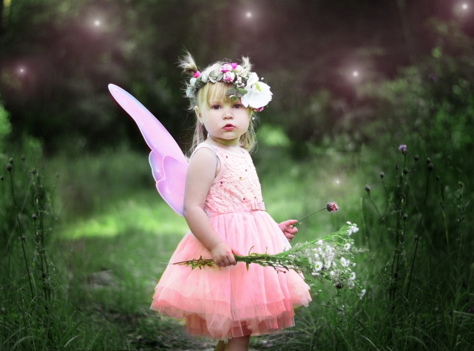 站在草丛间头带花环穿着花仙子长裙的可爱女孩写真