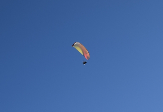 蓝色天空中滑行的滑翔伞运动员