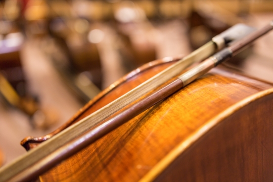 摄影基础_室内灯光下木制小提琴乐器上琴弓特写