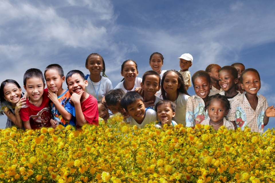 蓝天白云亚洲和非洲儿童在黄色花朵前