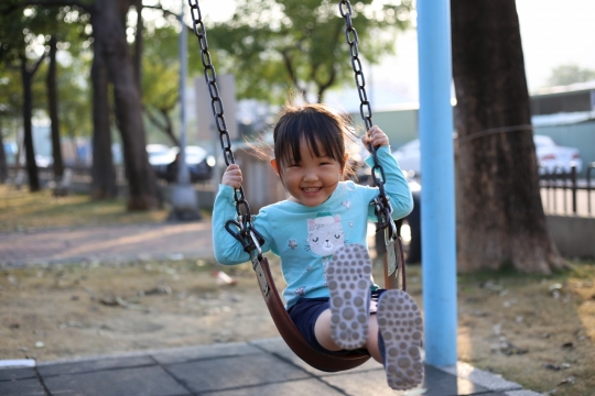 城市街道公园荡秋千可爱女孩