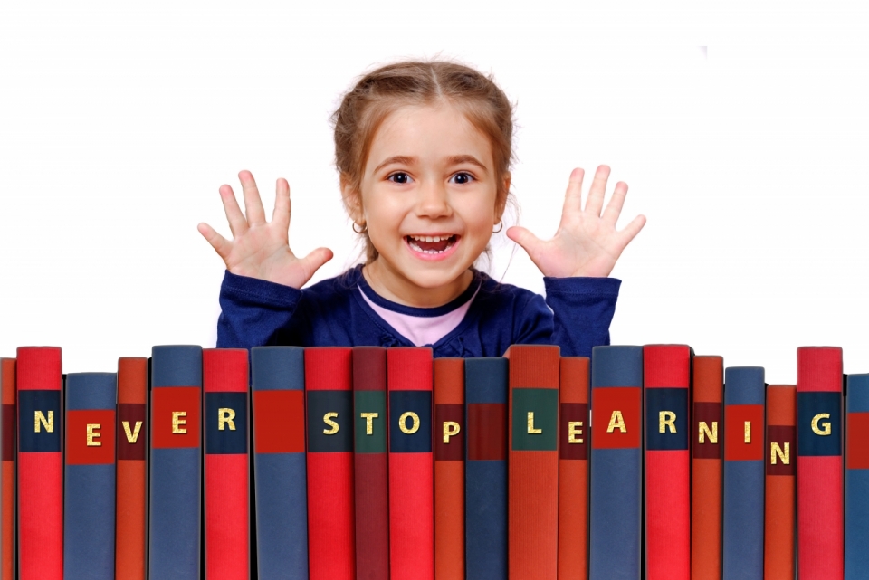 小女孩站在彩色书本前张开五指开心微笑