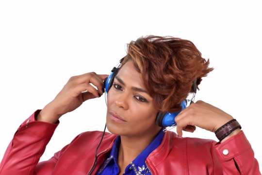 人物摄影_白色背景戴蓝色头戴式耳机专注音乐黑人女性