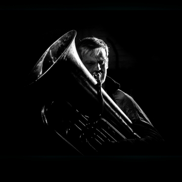 黑暗中神情吹奏着大号的中年男子