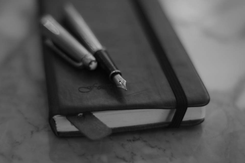 黑白风格大理石上的笔记本和钢笔