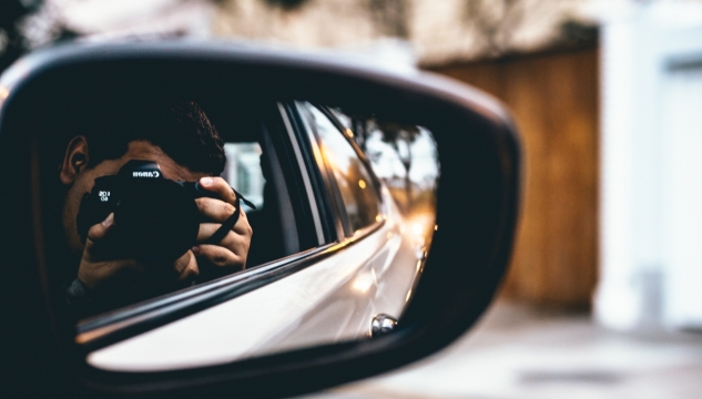 背景虚化汽车反光镜中的摄影男子