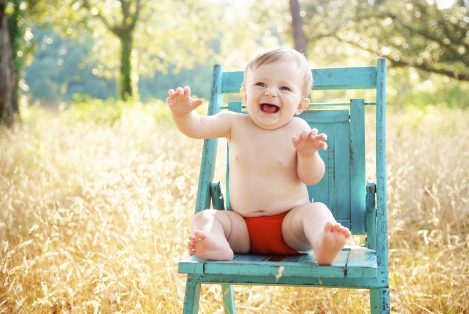 阳光户外坐蓝色木制板凳可爱婴儿