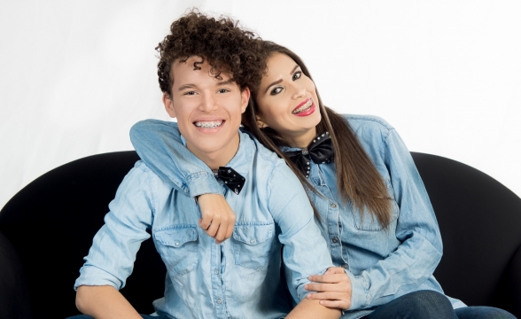 白色背景黑色沙发上亲密穿情侣装男女