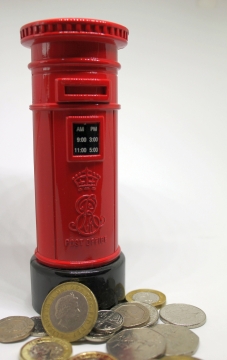 白色背景红色塑料信箱存钱罐边硬币