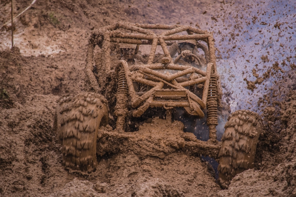 赛车竞技比赛在泥潭中开着全地形越野赛车的赛车手