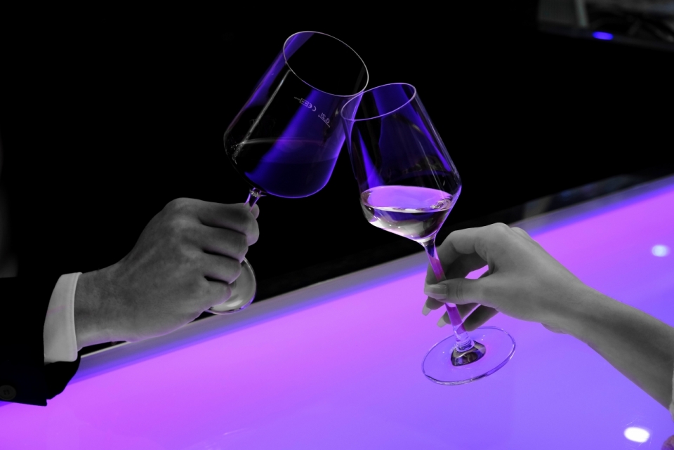 男性女性室内紫色灯光桌子上干杯