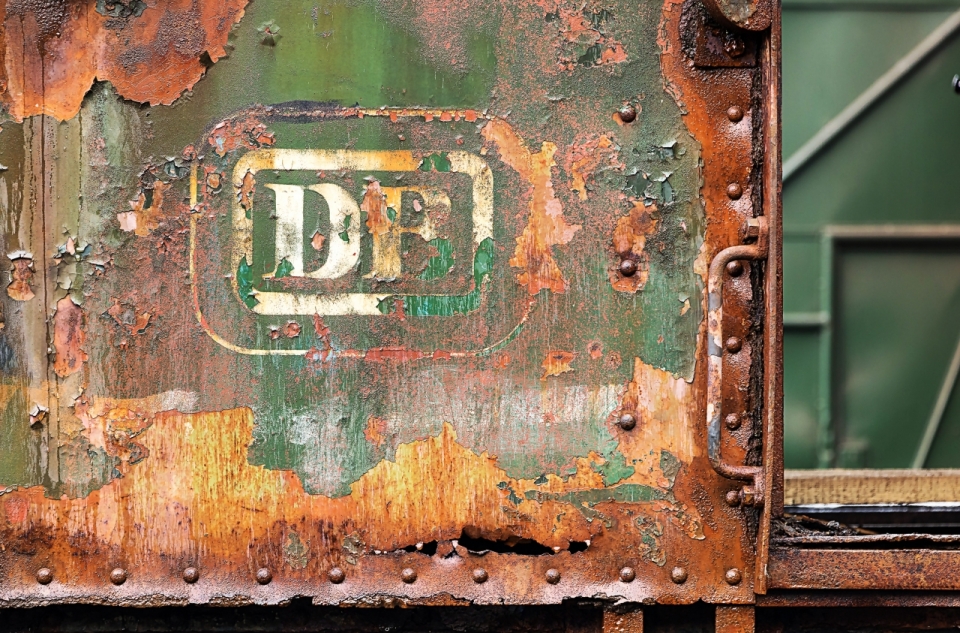 斑驳生锈的老式绿皮火车车门特写