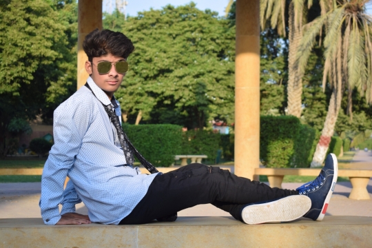穿着蓝色衬衫带着墨镜坐在地上的男模摄影