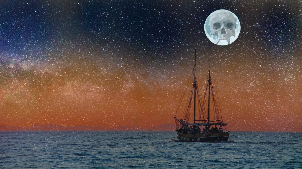 月亮星空下的海面上航行的船只