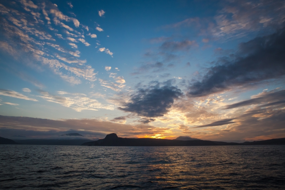 平静湖面落日山峰自然风景