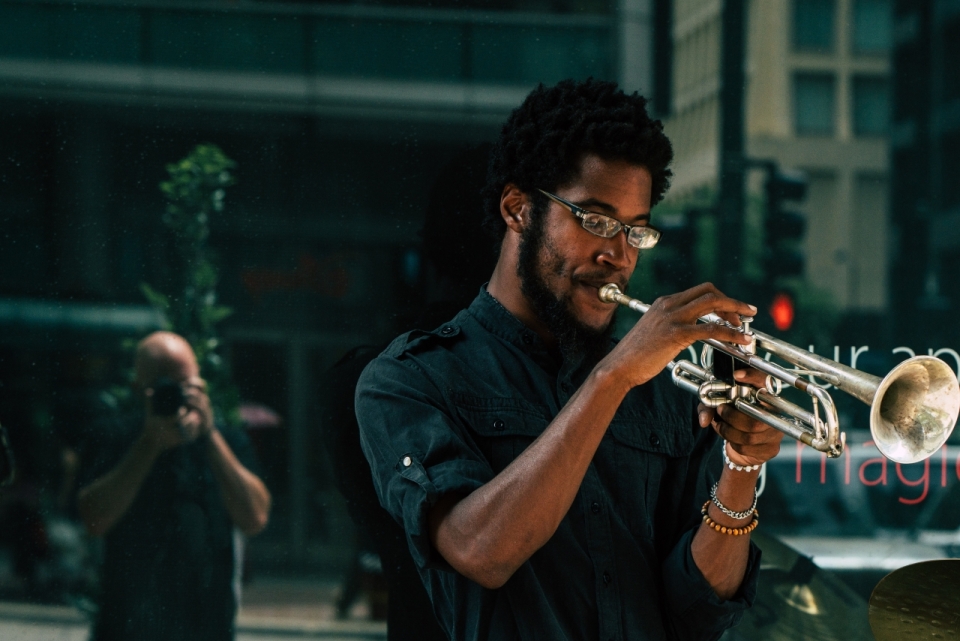 在大街上演奏小号乐器的黑人