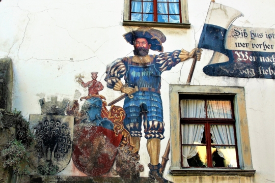 白墙上绘画英国骑士拿着国旗身边有红色护盾