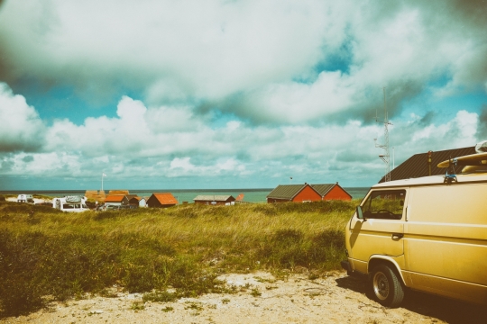 蓝天白云大海边的房屋草地风景