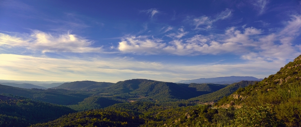 蓝天白云下连绵的绿色高山山脉风景摄影