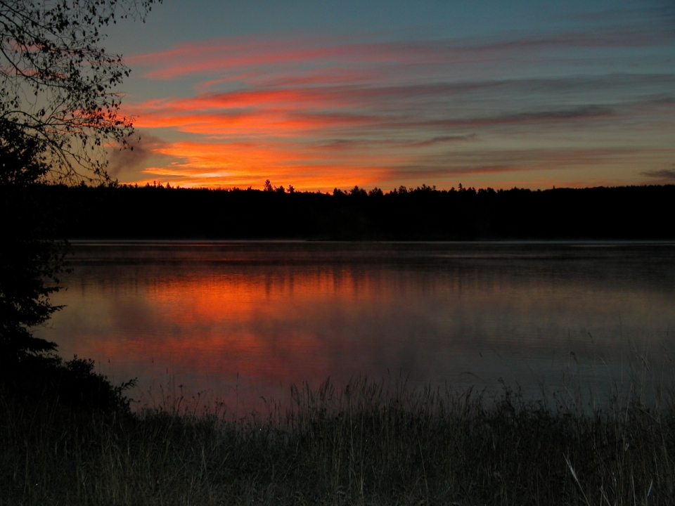 夕阳晚霞树林围绕的湖泊风光