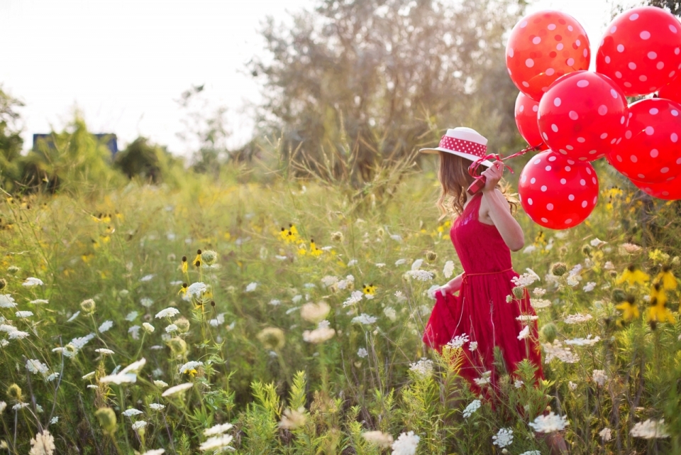 牵着气球漫步在花草丛中的美少女