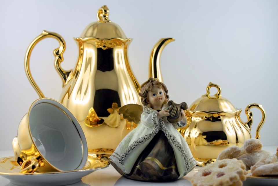 桌子上洛丽塔公主玩偶和金色茶杯还有饼干
