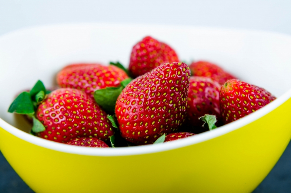 黄色碗中的新鲜美味的水果草莓摄影