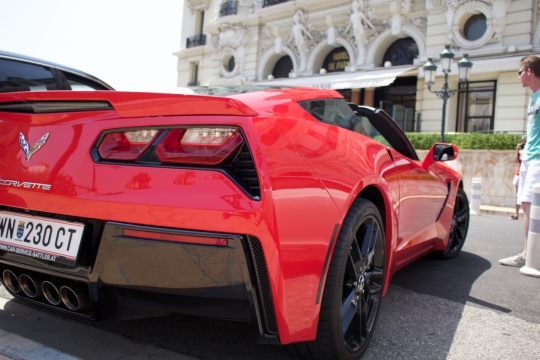 阳光城市街道路边红色崭新跑车