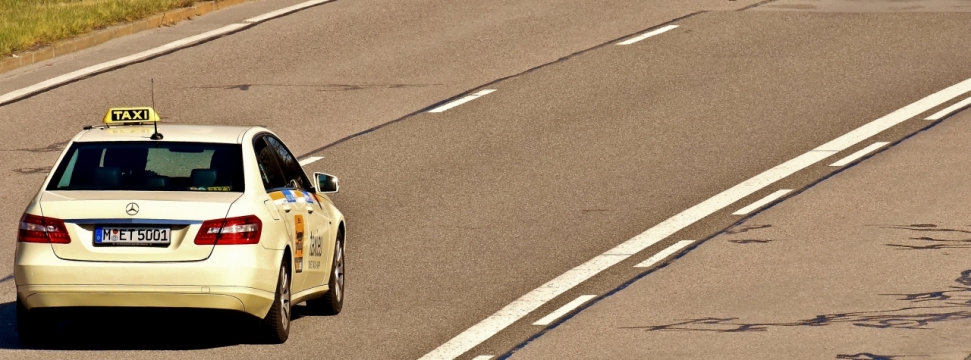 阳光城市街道马路上白色出租车