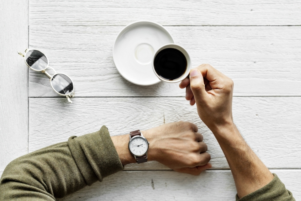 文艺白色木制桌面戴手表男性喝咖啡