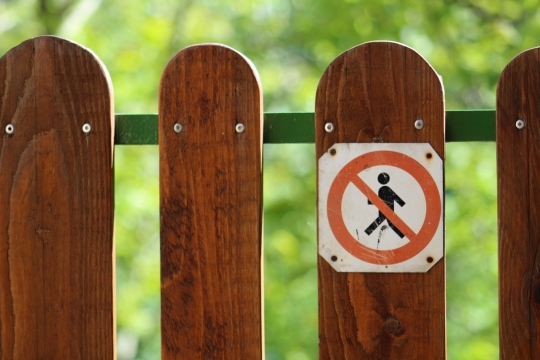 户外自然植物前木制栏杆警示标识