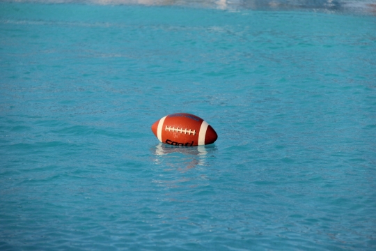 平静蓝色湖面漂浮橄榄球外景