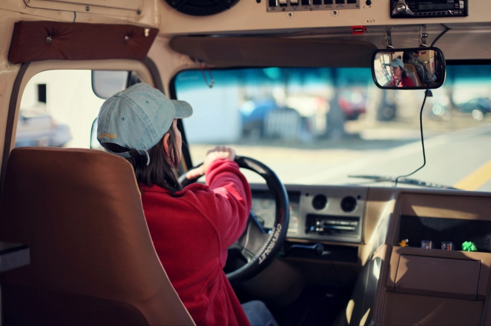 城市马路上长发女性司机驾驶汽车