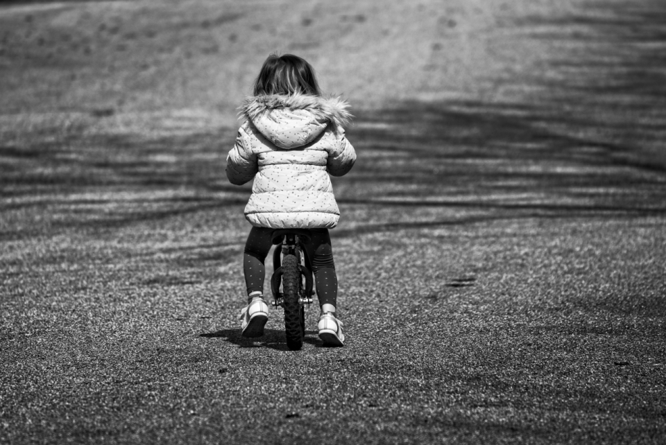 黑白城市街道骑儿童自行车女孩