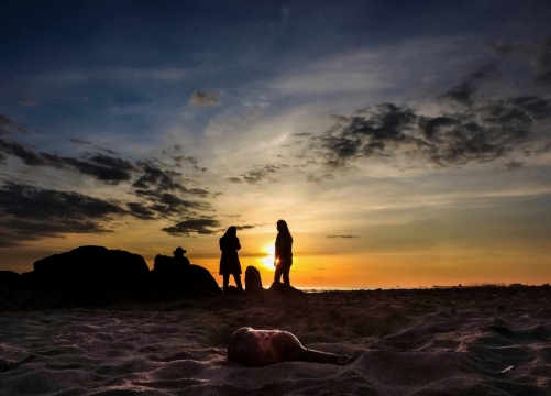 傍晚夕阳海边沙滩逆光人群