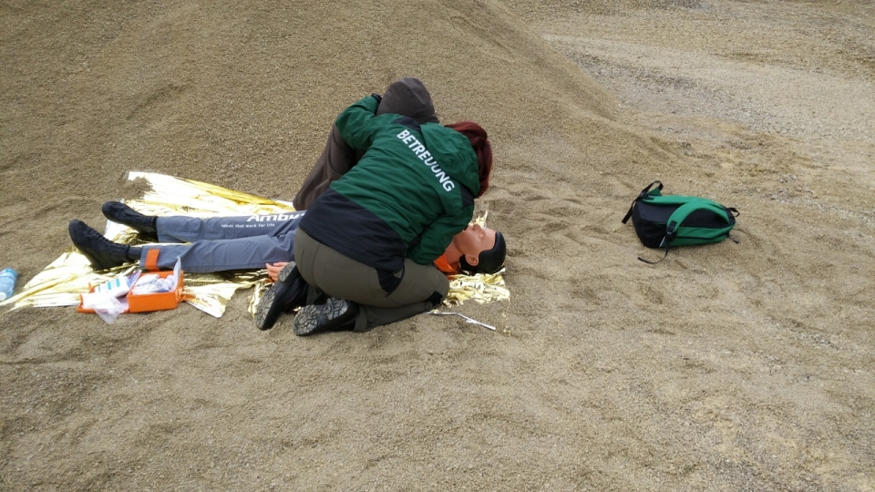 正在沙滩上用假人练习溺水抢救的工作人员