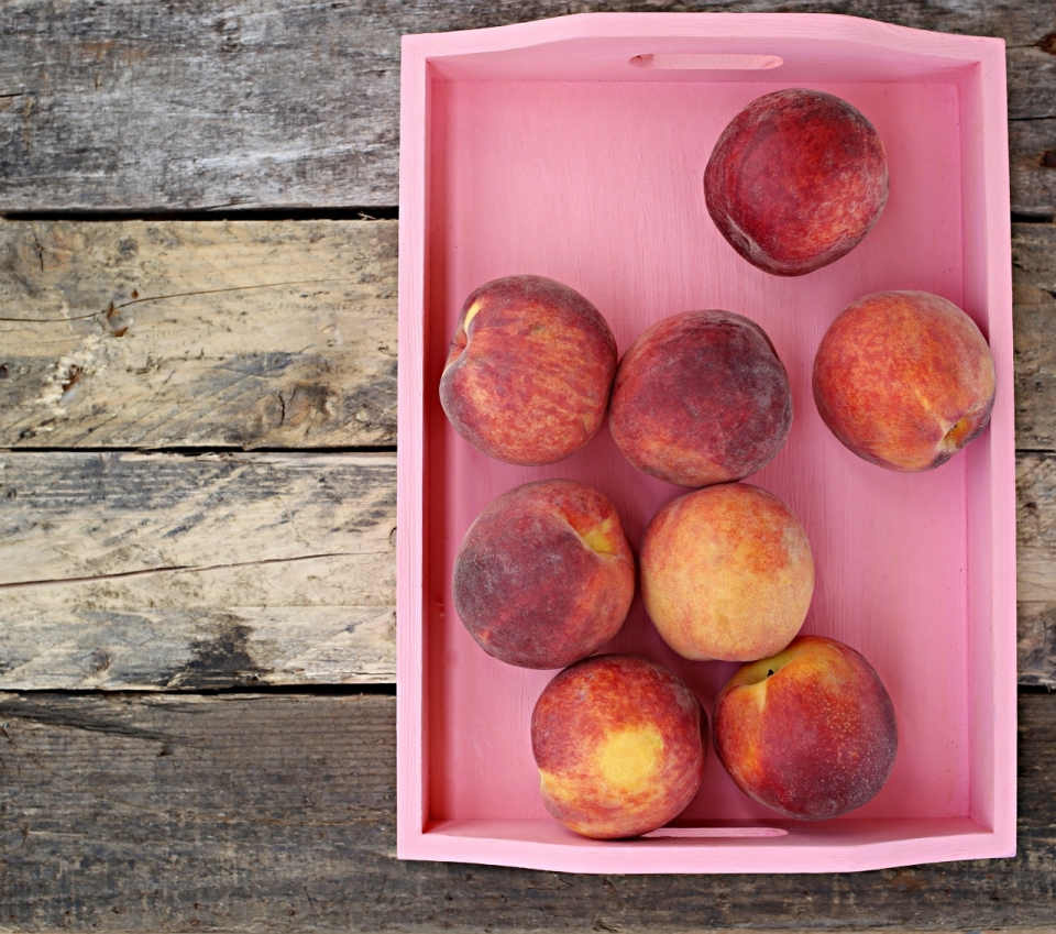 木制桌面粉色托盘新鲜美味桃子水果