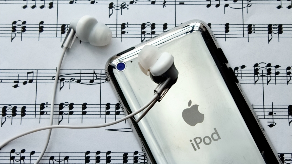 摆放在乐谱上的ipod和耳机