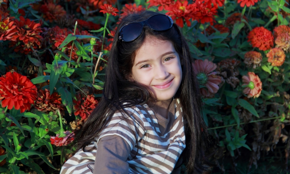 红色鲜花前长发小女孩甜美微笑儿童写真