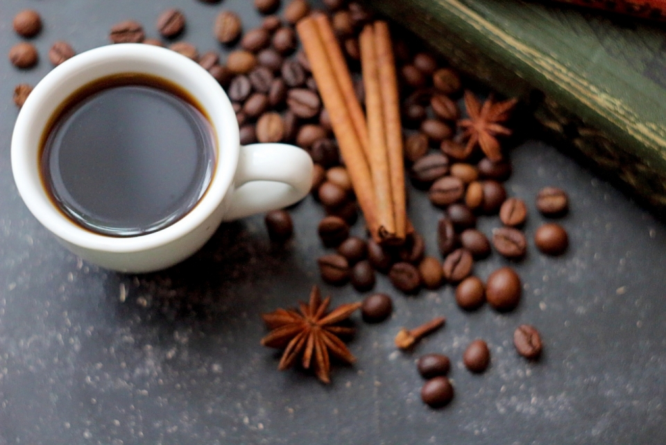 泡好的咖啡与散落的咖啡豆辛香料