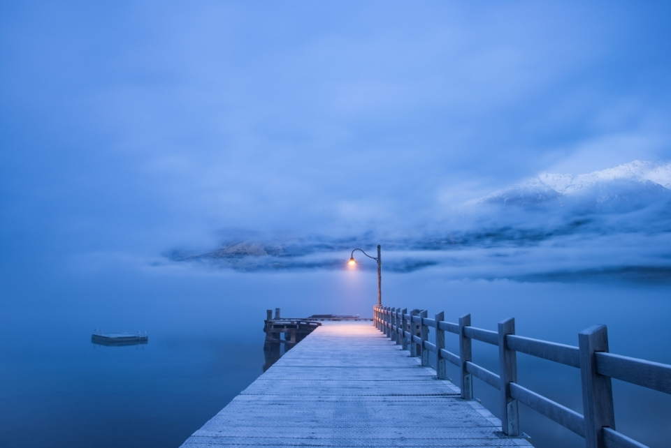雪山脚下湖泊木桥弥漫雾气路灯景观